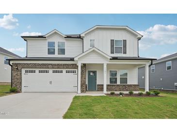 Charming two-story home with a white facade, brick accents, and a spacious two-car garage at 1121 Landen Creek Ln, Zebulon, NC 27597