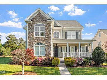 Inviting two-story home featuring a stone facade, covered porch, and beautifully landscaped front yard at 134 Barclay Valley Dr, Cary, NC 27519