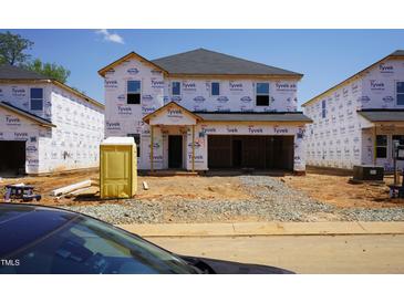 New home construction in progress with Tyvek house wrap and a portable toilet in the front yard at 2218 Cherry Creek Rd, Haw River, NC 27258