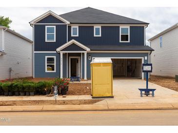 Two-story home featuring a two-car garage, a mix of blue and light blue siding, and white trim around the windows and front door at 2218 Cherry Creek Rd, Haw River, NC 27258