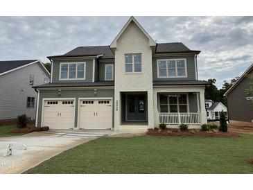 Charming two-story home boasts a two-car garage, covered porch, and lush green lawn at 2324 Eagle Shot Ct # 19, Fuquay Varina, NC 27526