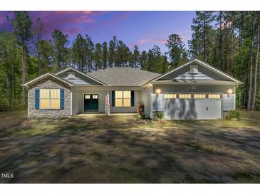Charming single-story home with stone accents, a two-car garage, and a well-manicured yard at 2784 Norrington Rd, Lillington, NC 27546