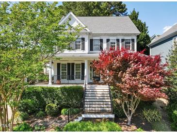 Charming two-story home with a welcoming front porch and beautifully landscaped front yard at 402 Vatersay Dr, Apex, NC 27502