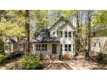 Charming two-story home with a covered front porch and mature trees surrounding the property at 4936 Liverpool Ln, Raleigh, NC 27604