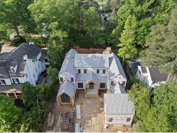 An aerial view showcases a house under construction, featuring a modern design and surrounded by lush greenery at 516 Transylvania Ave, Raleigh, NC 27609