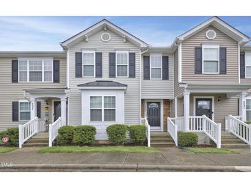 Charming townhome featuring neutral siding, a welcoming front porch, and well-maintained landscaping at 5329 Big Bass Dr, Raleigh, NC 27610