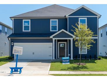 Charming blue two-story home with a well-manicured lawn and a one car garage at 630 White Birch Ln, Angier, NC 27501