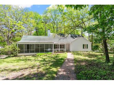 Charming home featuring a screened porch, lush greenery, and a quaint brick pathway at 803 Old Mill Rd, Chapel Hill, NC 27514