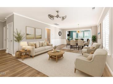Bright living room featuring hardwood floors, neutral furniture, and seamless access to the dining area at 1206 Areca Way, Durham, NC 27703