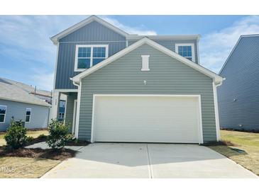 Charming two-story home featuring a two-car garage, landscaped front yard, and classic curb appeal at 129 N Keatts Winner Ct, Wilson's Mills, NC 27520