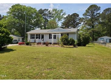 Charming single-story home with a well-manicured lawn, mature trees, and a welcoming front porch at 206 Lane Of Tristram, Garner, NC 27529