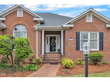 Charming brick home featuring a welcoming front entrance with a beautifully landscaped walkway at 208 E Harrington Ave, Broadway, NC 27505