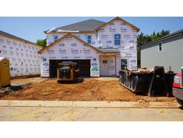 Exterior view of a home under construction with Tyvek wrap and heavy equipment at 2233 Cherry Creek Rd, Haw River, NC 27258
