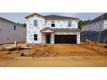 New two-story home under construction with Tyvek wrap and a two car garage at 2239 Cherry Creek Rd, Haw River, NC 27258