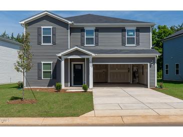 Charming two-story home features a well-kept lawn and an attached two-car garage at 2239 Cherry Creek Rd, Haw River, NC 27258