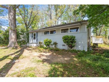 A charming single-story house with a brick facade and mature trees in the front yard at 2343 Derby Dr, Raleigh, NC 27610