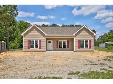 Charming single-story home with tan siding, red shutters, and a well-manicured lawn at 2820 Tara Dr, Clayton, NC 27520