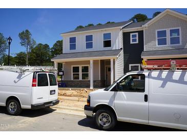 Two-story home with modern facade, large windows, and welcoming porch in a neighborhood setting at 3701 Rosebush Dr, Zebulon, NC 27597