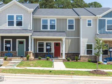 Charming townhomes featuring craftsman-style architecture, covered entryways, and well-manicured lawns create inviting curb appeal at 3705 Rosebush Dr, Zebulon, NC 27597