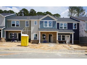 New townhomes showcase modern facades, each distinguished by varying siding colors and brick foundations at 3707 Rosebush Dr, Zebulon, NC 27597