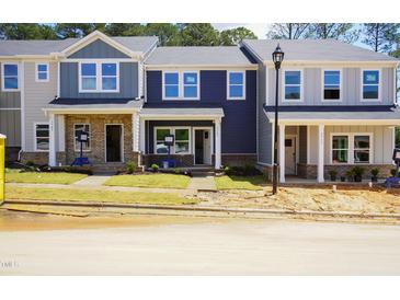 Charming, newly constructed townhomes with colorful facades and inviting front lawns at 3709 Rosebush Dr, Zebulon, NC 27597