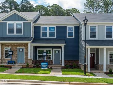 Charming townhomes with blue siding, brick accents, and well-maintained front yards at 3709 Rosebush Dr, Zebulon, NC 27597