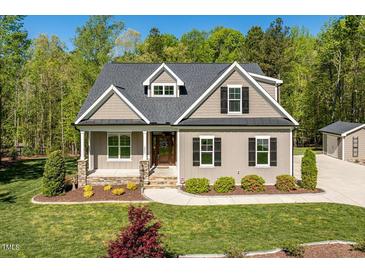 Charming home featuring a manicured lawn, stone accents, and inviting front porch at 3805 Watermark Dr, Franklinton, NC 27525