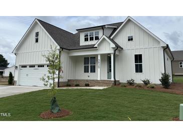 Charming two-story white home featuring a covered porch, attached garage, and manicured lawn at 3820 Fairway View Dr # 16, Fuquay Varina, NC 27526