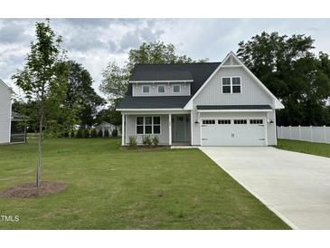 Charming two-story home with gray siding, a well-manicured lawn, and an attached two-car garage at 520 S Lincoln St, Benson, NC 27504