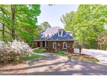 Charming brick home with a beautiful paved driveway and well-maintained landscaping at 5504 Spring Bluffs Ln, Raleigh, NC 27606