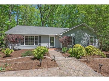 Charming single story home featuring manicured landscaping and a brick pathway to the front door at 6614 Chantilley Place, Bahama, NC 27503