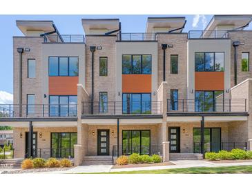 Modern townhomes showcasing a brick facade, balconies, and sleek black metal railings at 1012 Manor Way, Durham, NC 27701