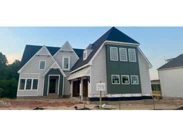 New construction home showing gray and green color scheme, many windows, and peaked roof lines at 1021 Azalea Garden Cir, Raleigh, NC 27603