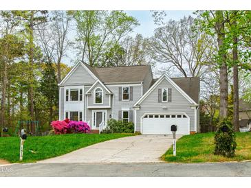 Charming two-story home featuring gray siding, attached garage, and colorful landscaping at 1412 Amberton Ct, Raleigh, NC 27615
