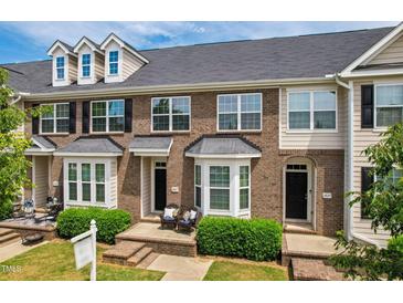 Charming brick townhome with a cozy front porch and well-maintained landscaping at 2027 Hayes Ln, Holly Springs, NC 27540