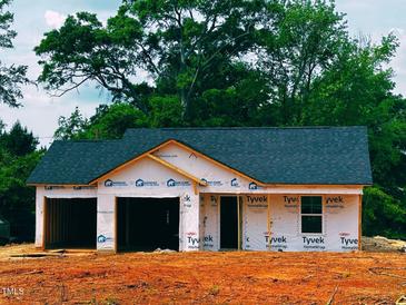 Exterior view of a new home under construction with a two-car garage in a well-wooded area at 2243 Melfield Dr, Haw River, NC 27258
