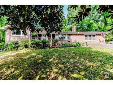 Charming brick home with a well-maintained front yard, lush landscaping and inviting porch at 2307 Piedmont Dr, Sanford, NC 27330