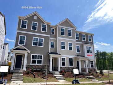 New two-story townhome features a stone facade, neutral siding and professionally landscaped yard at 4004 Silver Oak Ln, Durham, NC 27703