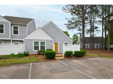 Charming townhome featuring a bright yellow door and a well-maintained, fenced front yard at 5000 Avenida Del Sol Dr, Raleigh, NC 27616