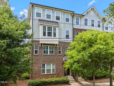 Three-story townhome with brick and shingle siding, surrounded by mature trees at 511 N Person St # 101, Raleigh, NC 27604