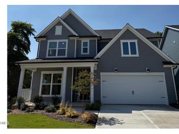 Charming two-story home with a two car garage and a welcoming front porch and well manicured landscaping at 760 Bachelor Gulch Way, Apex, NC 27523