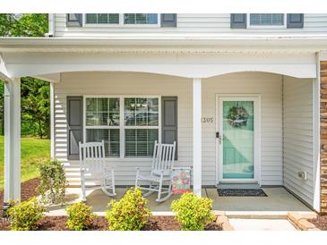 Charming front porch with rocking chairs and a tastefully decorated entrance at 1305 Montreux Ct, Mebane, NC 27302
