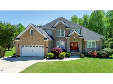 Charming brick home featuring a well-manicured lawn, mature landscaping, and a two-car garage at 226 Marshview Cir, Angier, NC 27501
