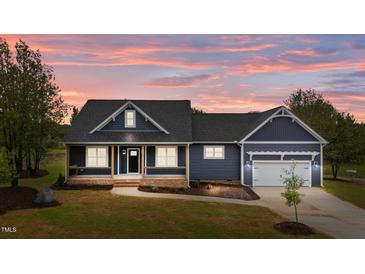 Charming home featuring a covered porch and an attached two-car garage, with a beautiful sunset at 25 Leisure Ln # 2, Louisburg, NC 27549