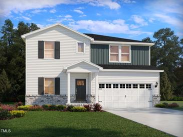 Charming two-story home with a well-manicured lawn and a two-car garage at 3845 Rosebush Dr, Zebulon, NC 27597