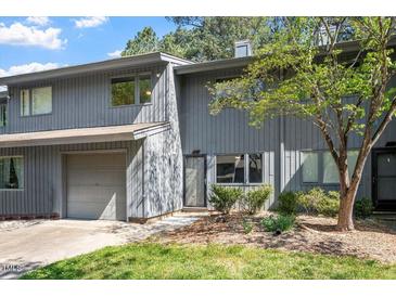 Charming townhome features a gray exterior, attached garage, and mature landscaping at 4318 Hunters Club Dr, Raleigh, NC 27606