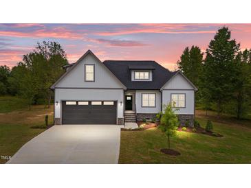 Charming new construction home featuring a two-car garage, stone accents and lush landscaping at 45 Leisure Ln # 4, Louisburg, NC 27549