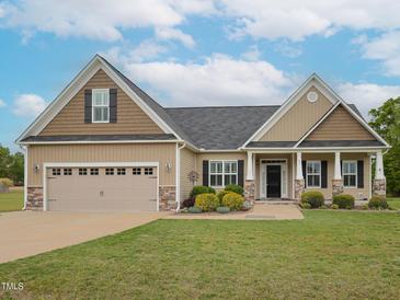 Charming single Gathering home featuring a manicured lawn, two car garage, and inviting front entrance at 63 Whistling Duck Way, Wendell, NC 27591