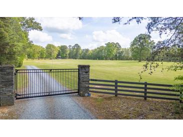 Estate home with a stone pillar gated entrance and long tree lined driveway leading to the residence at 6600(A) Maynard Farm Rd, Chapel Hill, NC 27516