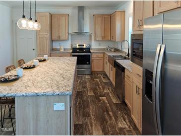 Charming kitchen with stainless steel appliances, a large island, and wood grain cabinets at 765 Whitley Rd, Middlesex, NC 27557